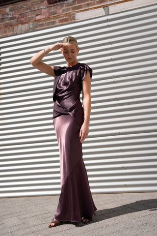 Model wearing the Bella Skirt in Aubergine paired with the Allure Draped Top.