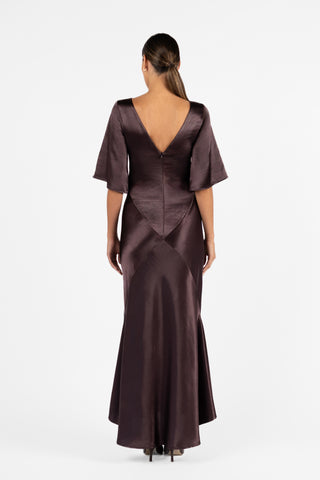 One Fell Swoop back view of the Moni Gown in Aubergine featuring a v neck line, sculptural bias panelling, full bra friendly and elbow-length sleeves. 