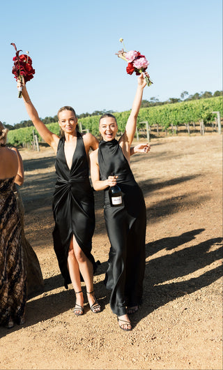 Bridesmaids wearing black One Fell Swoop dresses at vineyard wedding celebration