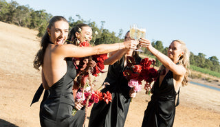 Bridesmaids wearing black One Fell Swoop dresses at vineyard wedding Champagne toast celebration
