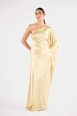 One Fell Swoop Arc Maxi in Dune, front three-quarter view showing the sleeve falling alongside the body, pale gold satin one shoulder dress.