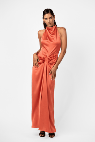 One Fell Swoop Caira Gown in Clay featuring a draped halter neckline, sculptural gathered waist and liquid satin maxi silhouette. 