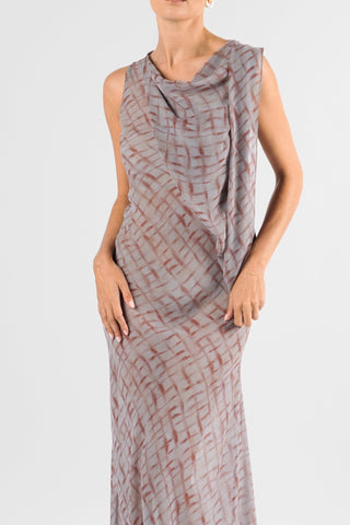 One Fell Swoop Glinch Gown in Ink Veil, close-up of the bodice showing the soft cowl neckline, the lightweight chiffon panel draping from the shoulder across the chest and the grey and rust-red brushstroke lattice print against a pale grey ground.